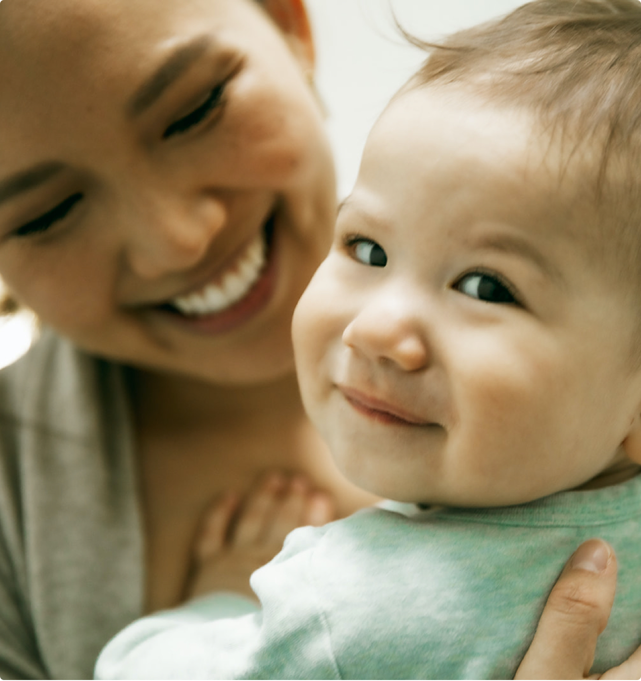 A smiling mother holding her baby.