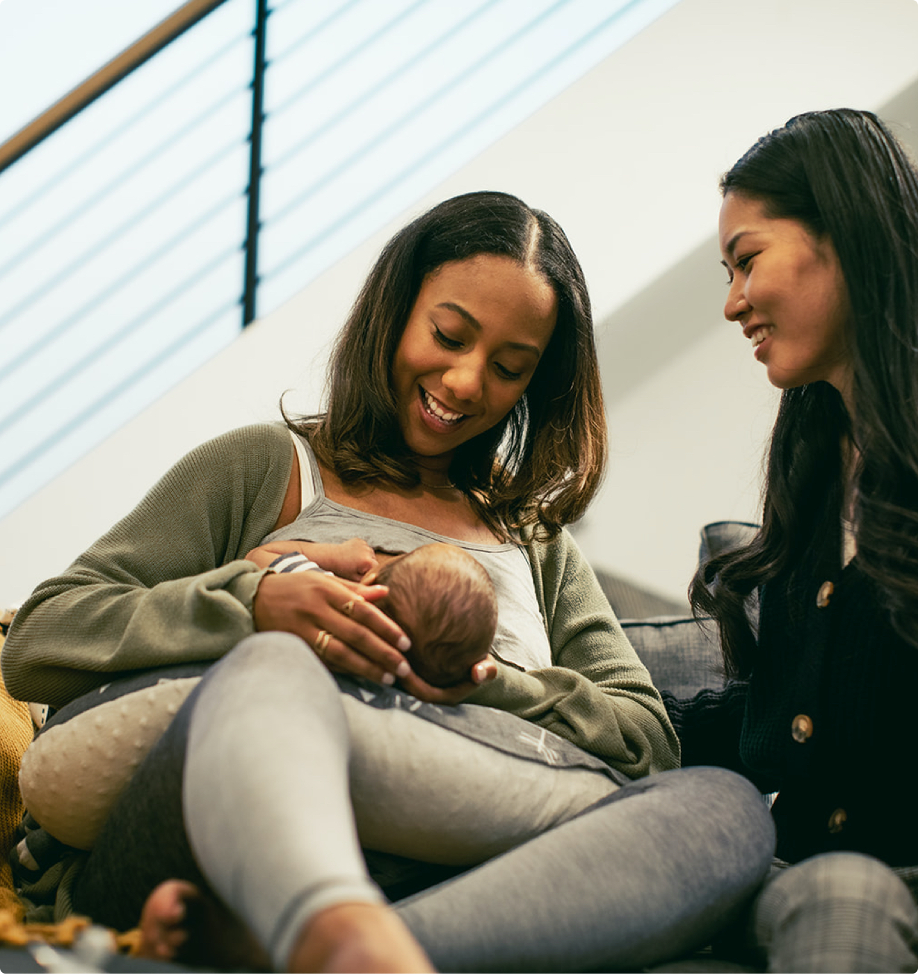 A mother breastfeeds her baby with support from her lactation consultant.