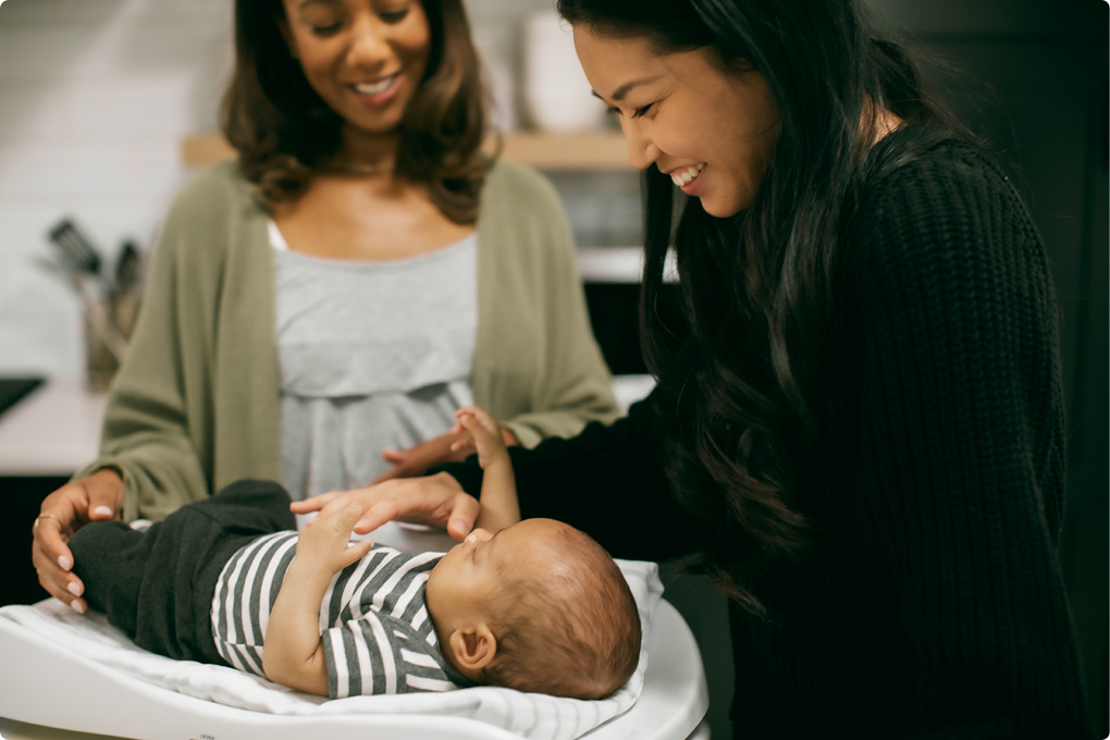 A parent cares for her baby with guidance from their lactation consultant.