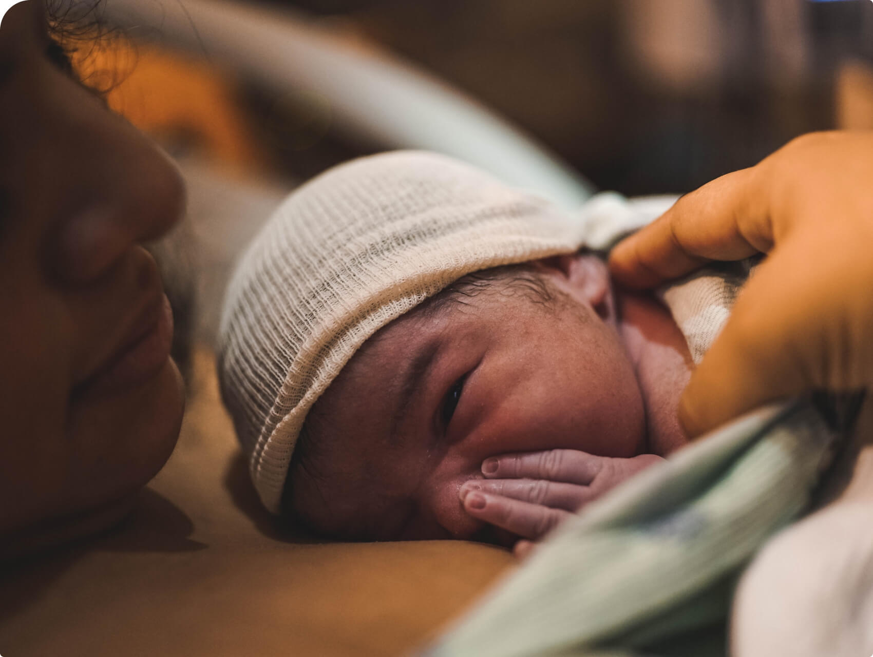 A newborn rests on their parent's chest shortly after birth, highlighting the importance of skin-to-skin bonding.