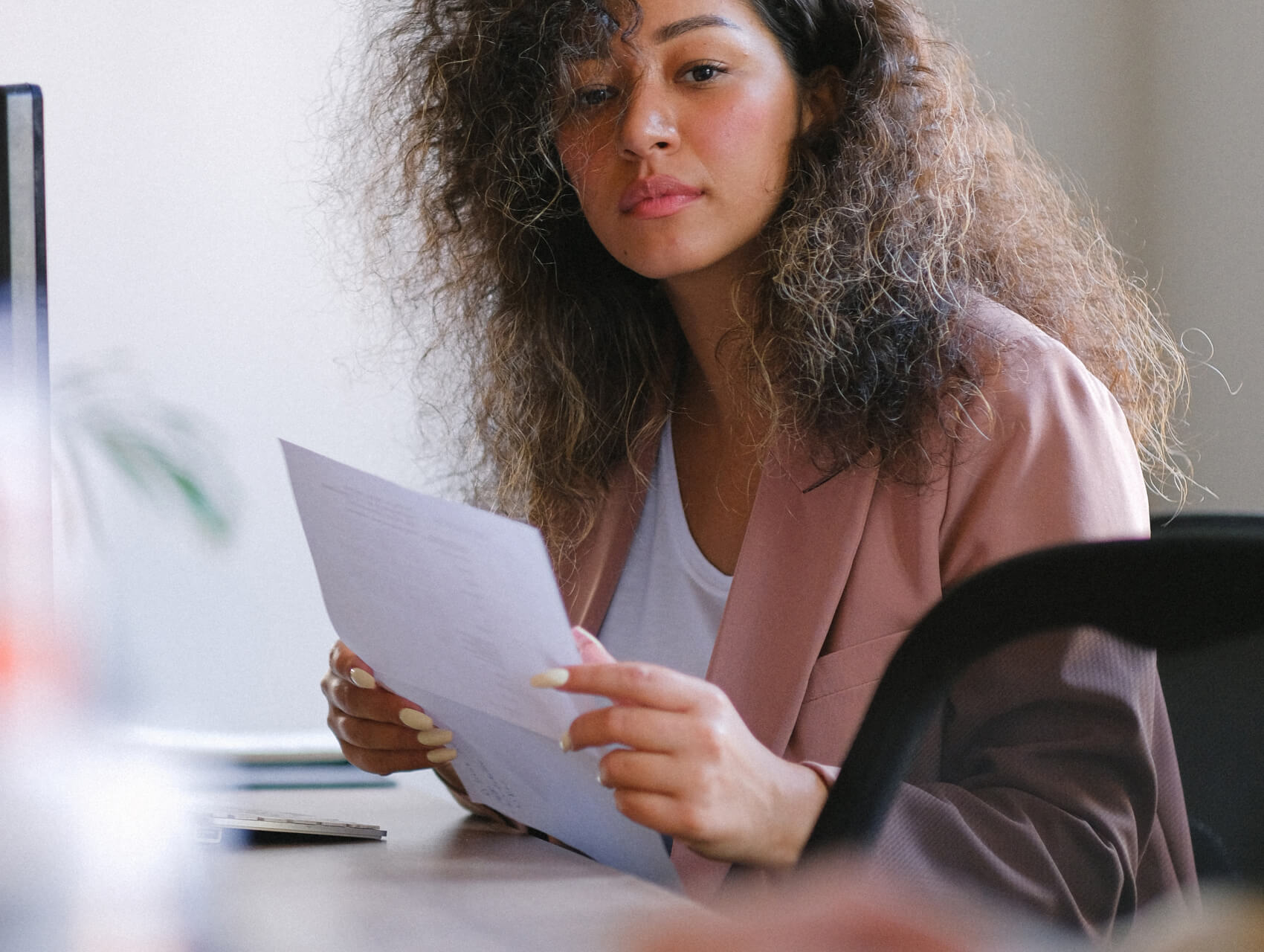 A professional reviewing documents at their desk focused on work tasks.