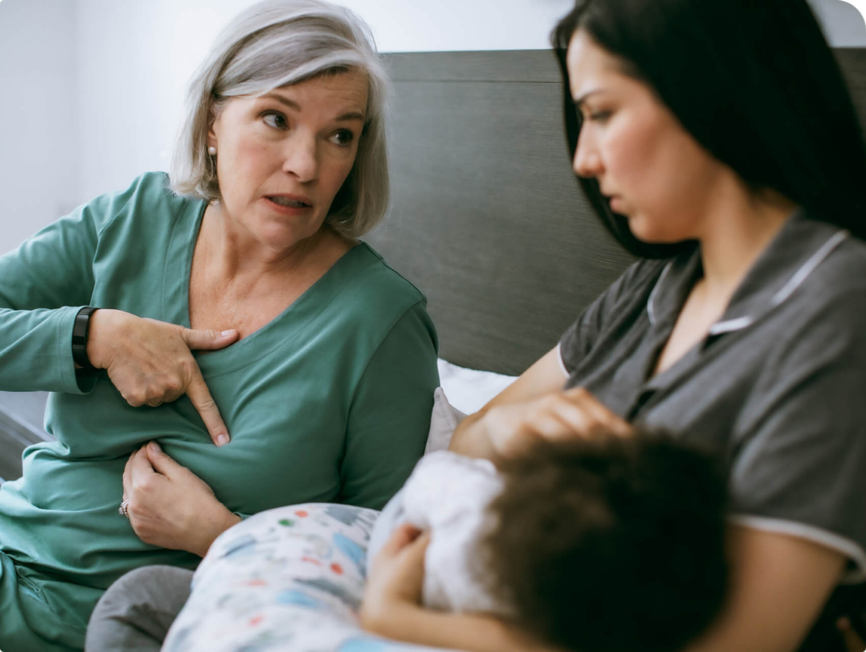 An International Board Certified Lactation Consultant demonstrates proper feeding techniques to a parent.