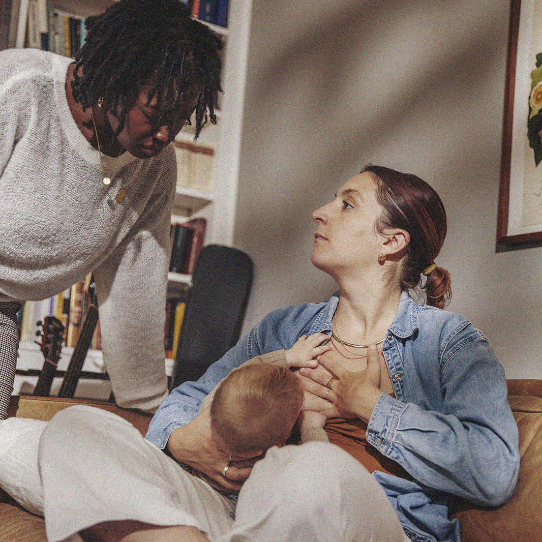 A mother chats with her IBCLC while nursing her infant during a home visit