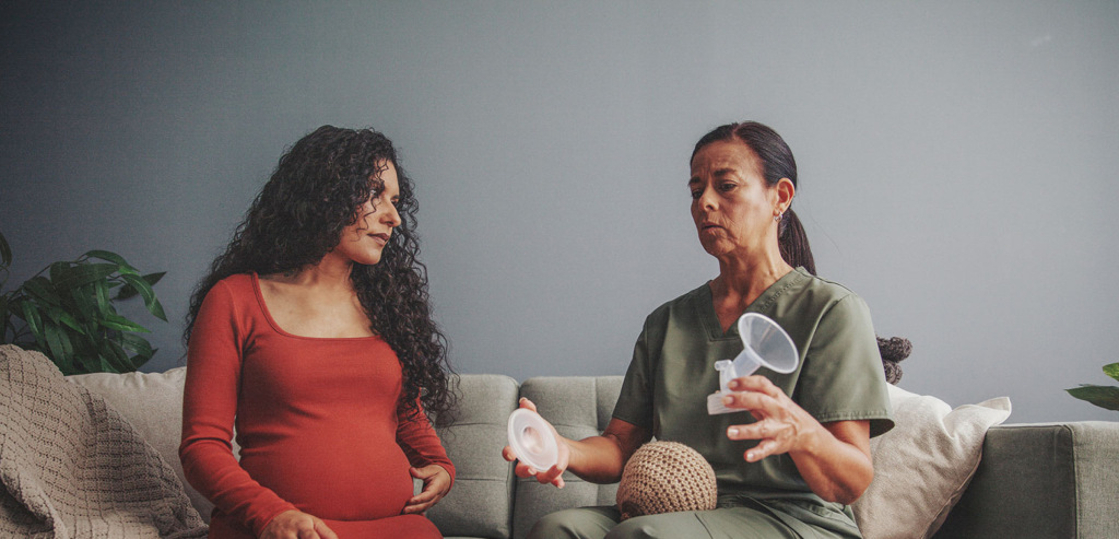 IBCLC shows pregnant parent breast pump parts during an at-home lactation consultation