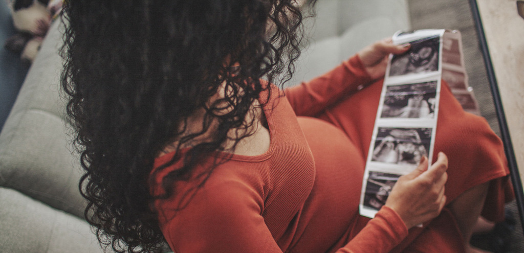 Pregnant woman looking at a sonogram.